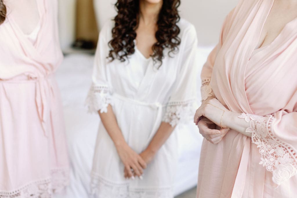 bride and bridesmaids standing together for a photo of their getting ready robes