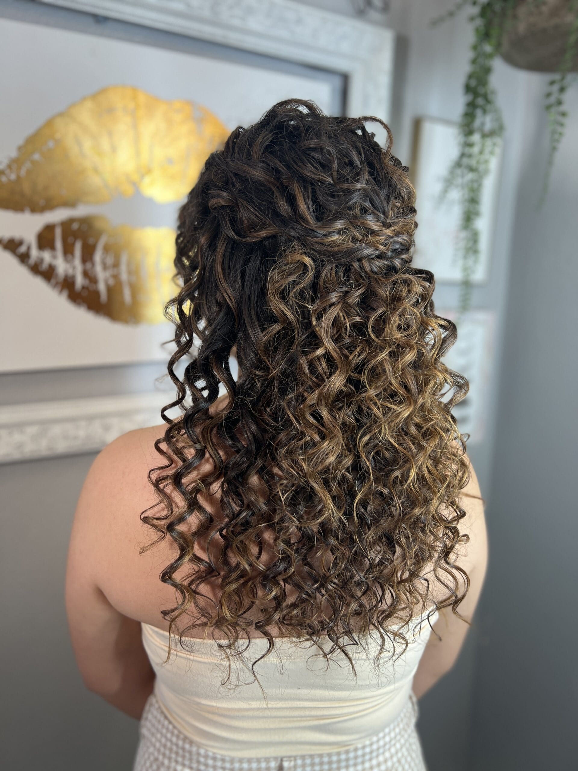Half-up curly hairstyle with defined ringlets and warm brunette tones, styled by Pacheco Beauty for long-lasting bounce