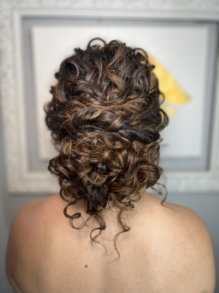 Elegant curly updo styled for an event by Pacheco Beauty featuring soft, defined curls with natural volumed and shine