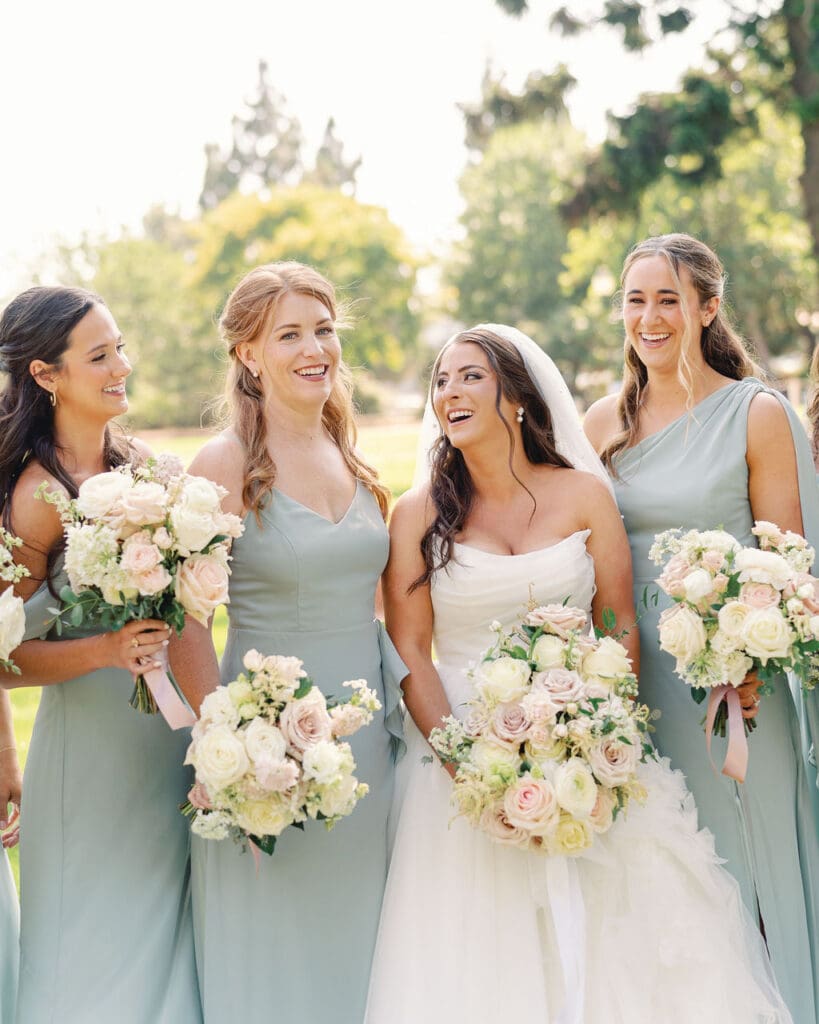 Wedding party and bride with wedding photographer for wedding portraits with professional glam.